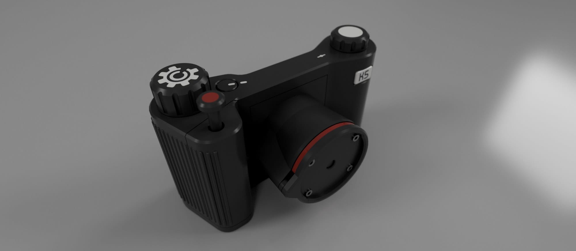 A rendering of the camera design from above, black with a red ring around the lens mount and the red shutter button standing up from the grip